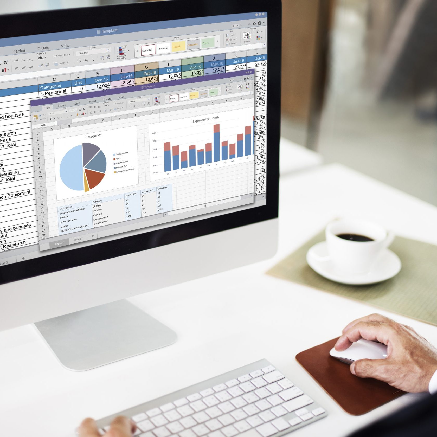 Computer screen with pie chart and graph, man's hand using a keyboard and mouse